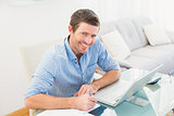 Smiling businessman writing at his desk
