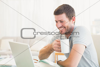 Casual businessman holding a mug at desk
