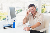 Smiling casual businessman working at his desk