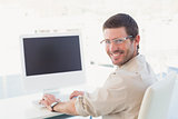 Smiling casual businessman at his desk