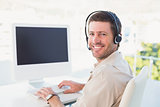 Businessman in headset smiling at camera