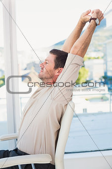 Casual businessman stretching in swivel chair