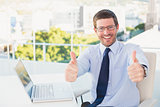 Smiling businessman showing thumbs up