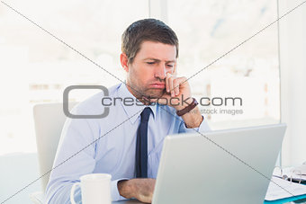 Confused businessman looking at his laptop