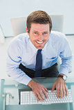 Smiling businessman using his computer