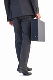 Rear view of businessman holding briefcase walking