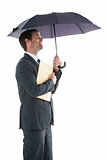 Smiling businessman holding a file under umbrella