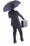 Businessman in suit holding umbrella and briefcase