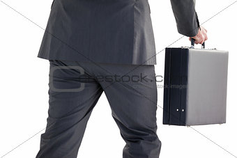 Handsome businessman holding briefcase walking