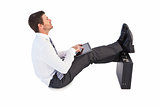 Businessman sitting with feet up while using his tablet