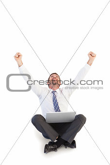 Excited cheering businessman sitting using his laptop