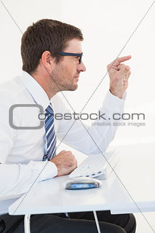 Businessman sitting at his desk pointing something