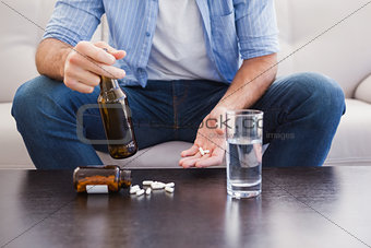 Close up of man showing pills and holding bottle