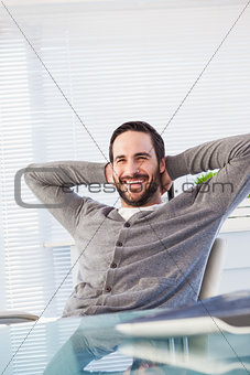 Relaxed casual businessman leaning back at his desk