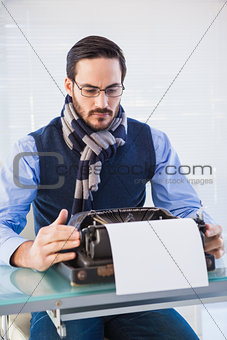 Serious businessman working on typewriter