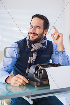 Smiling businessman working on typewriter