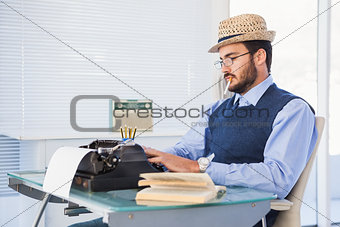Businessman working on typewriter while smoking