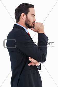 Thinking businessman standing with hand on chin