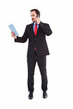 Businessman talking on phone holding tablet pc