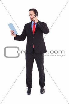 Businessman talking on phone holding tablet pc