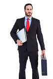 Handsome businessman holding briefcase and laptop