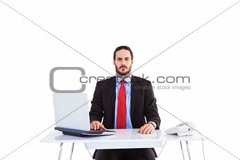 Unsmiling businessman sitting at desk