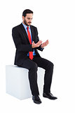 Thoughtful businessman sitting holding something