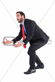 Bending businessman holding hand out while looking up