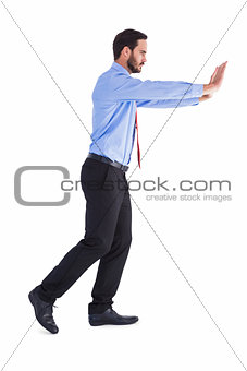 Businessman in suit pushing with effort