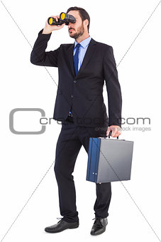 Businessman looking through binoculars holding briefcase