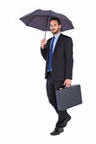 Businessman in suit holding umbrella and briefcase