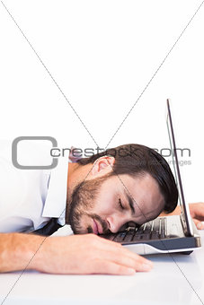 Businessman resting head on laptop keyboard