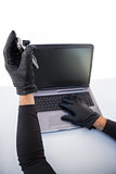 Burglar hacking laptop and mobile phone
