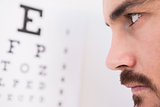 Focused man on eye test letters