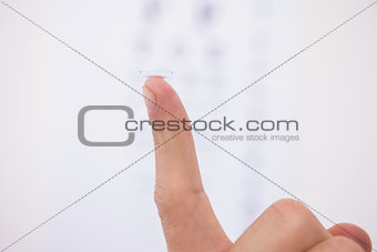 Close up on finger holding contact lens