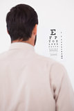 Focused man in suit on eye test letters