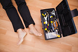 Handyman lying barefoot on floor with DIY tools
