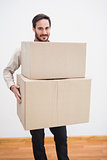 Smiling man holding a cardboard moving box