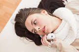 Pretty brunette making a phone call on bed