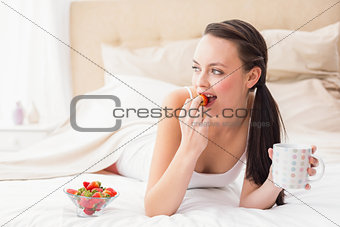 Pretty brunette having breakfast in bed