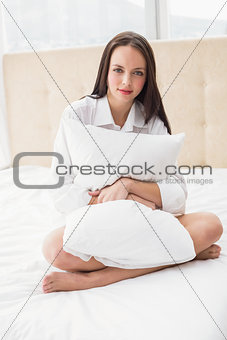 Pretty brunette sitting on bed