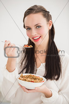 Pretty brunette eating bowl of cereal