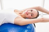 Fit brunette stretching on an exercise ball