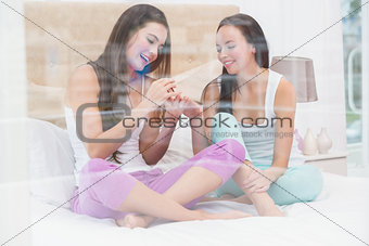 Pretty brunette painting her friends nails