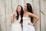 Pretty friends smiling in white dresses
