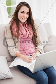 Pretty brunette using laptop on the couch