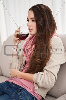 Pretty brunette drinking wine on couch