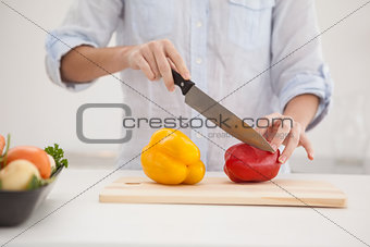 Pretty brunette slicing up peppers