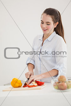 Pretty brunette slicing up peppers
