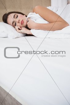 Pretty brunette lying in bed sleeping